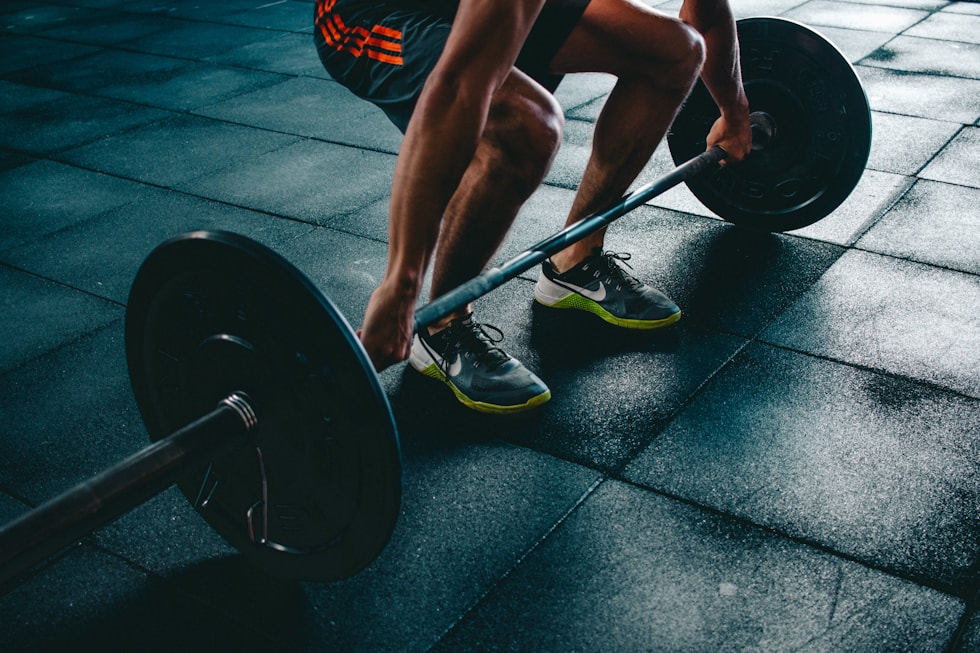 Athlete training with weights in performance apparel